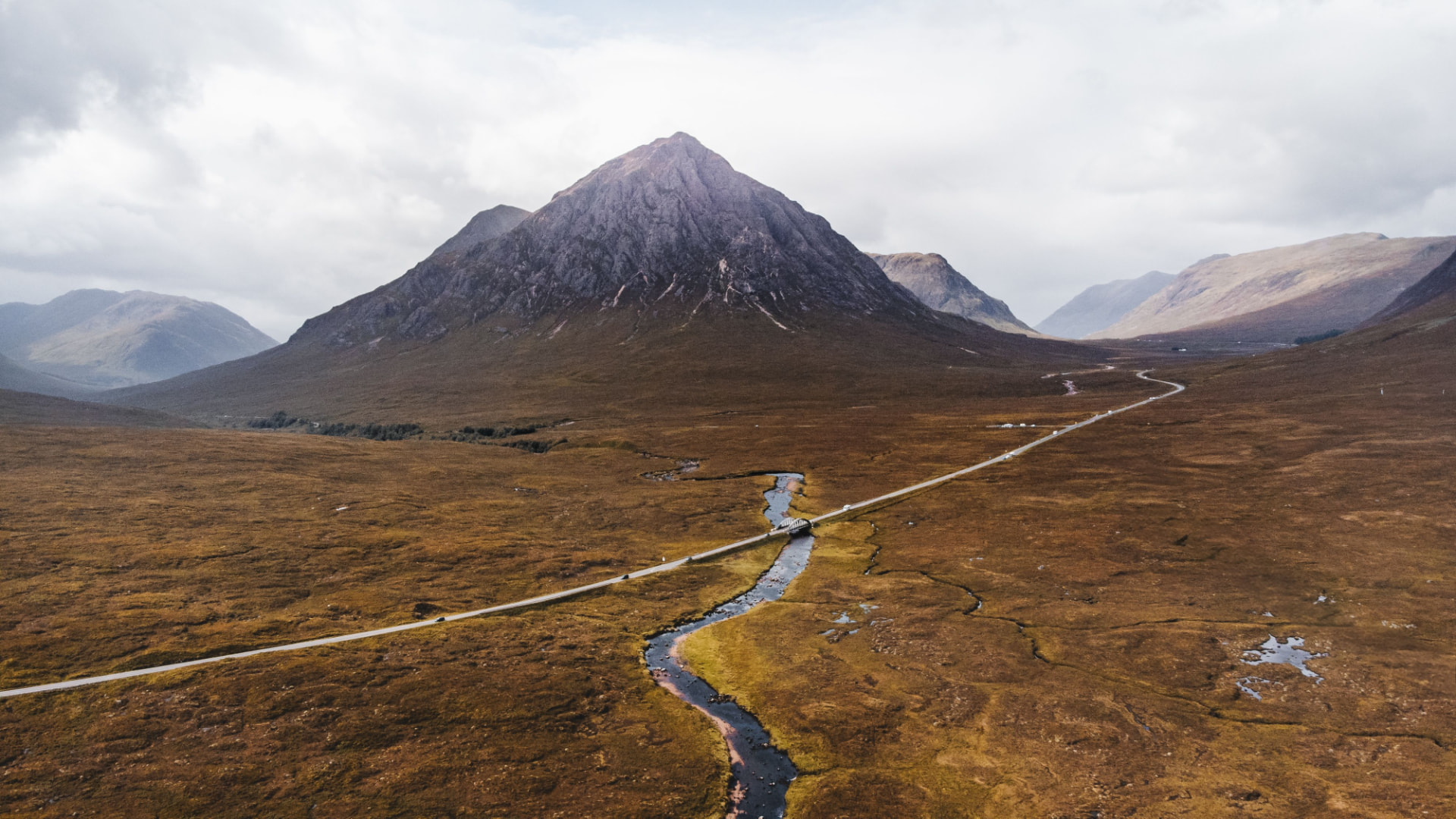 Road through a Glencoe glen beneath a Highland mountain