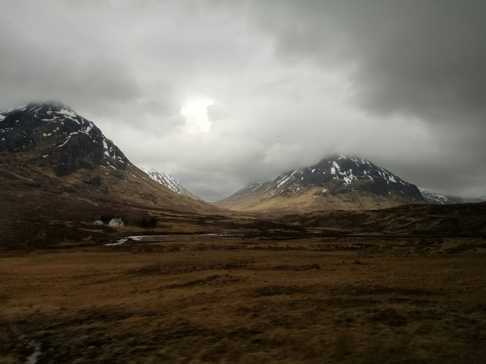 Snow-dusted glen in Glencoe under low cloud